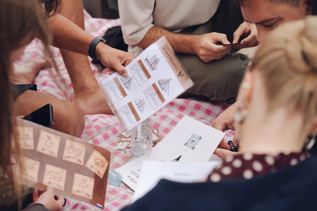 Colleagues solving a puzzle game together on a picnic blanket